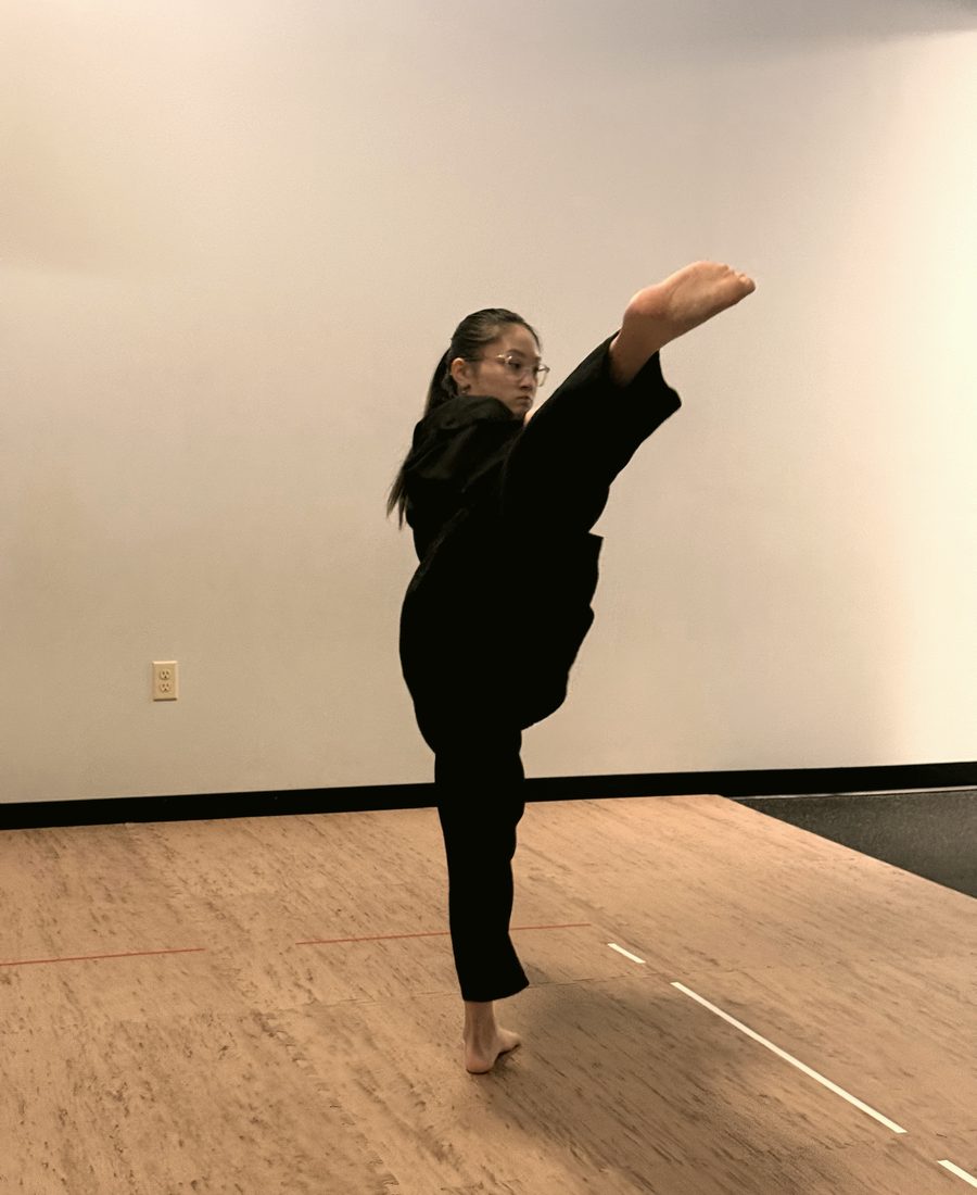 A teen martial artist practicing a high kick
